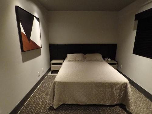 Säng eller sängar i ett rum på Apartamento Conceito Barra Sul