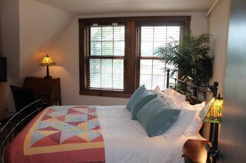 a bedroom with a bed with a quilt on it at Iowa House Historic Inn in Ames