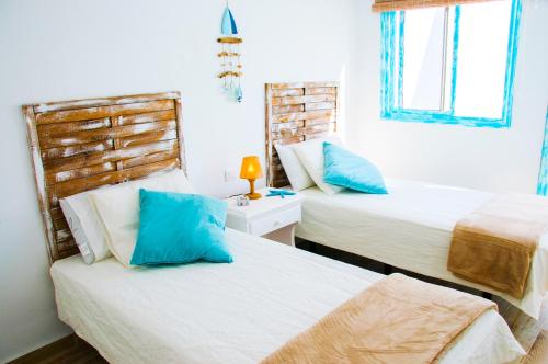 カレタ・デ・ファマラにあるCasa Ada 2のベッドルーム1室(青い枕のベッド2台付)