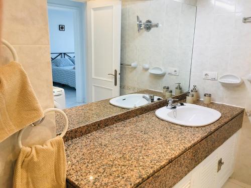 a bathroom counter with two sinks and a mirror at EL Drago in Costa Teguise