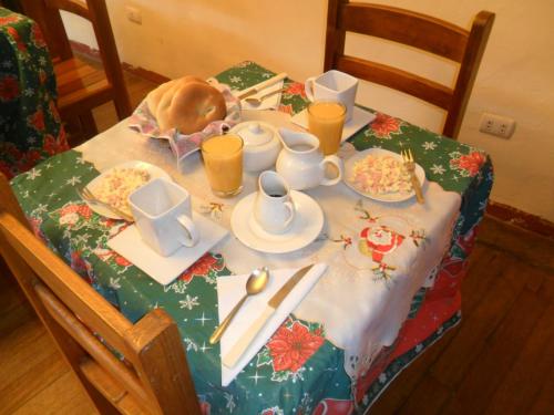 un gato sentado en una mesa con un mantel de Navidad en Chaquill Chak'a, en Cusco