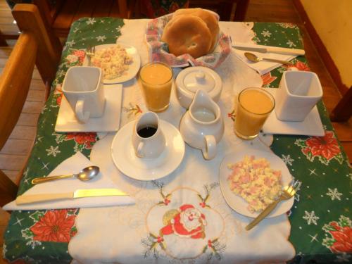 a table topped with plates of food on a christmas table at Chaquill Chak'a in Cusco