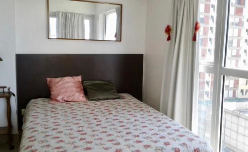 um quarto com uma cama com um espelho e uma janela em Mar del Plata em Mar del Plata