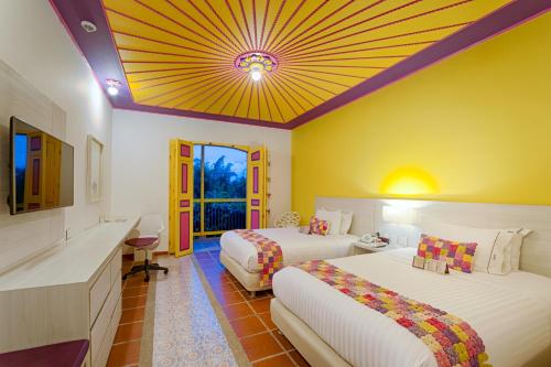 a hotel room with two beds and a ceiling at Hotel Mocawa Resort in La Tebaida