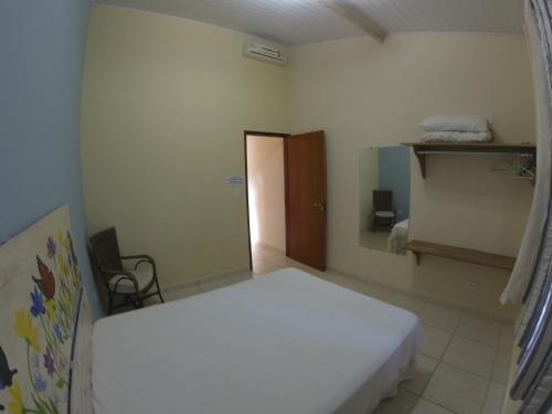 ein Schlafzimmer mit einem weißen Bett in einem Zimmer in der Unterkunft Casa do Monge Apartments in Ilhabela