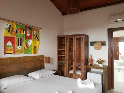 a bedroom with two beds and a book shelf at Pousada João Sol in Praia do Forte