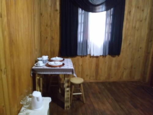 a small table in a room with a window at Pousada Bica D'Água in Lages