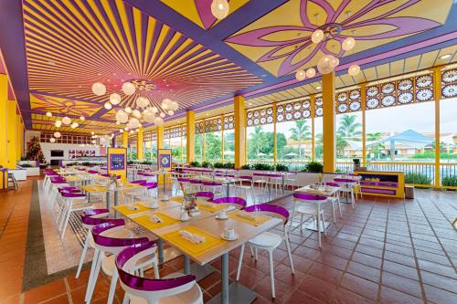 uma sala de jantar com mesas e cadeiras roxas em Hotel Mocawa Resort em La Tebaida