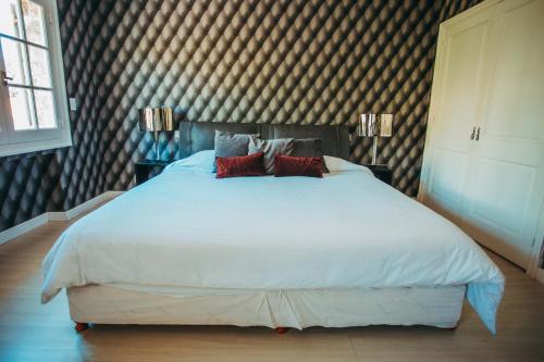 a bedroom with a large white bed with two pillows at Casa Daupi in Mar del Plata