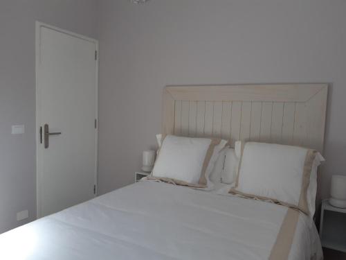 a bedroom with a white bed with two pillows at Casa La Alameda,Valle Gran Rey, La Gomera in Valle Gran Rey