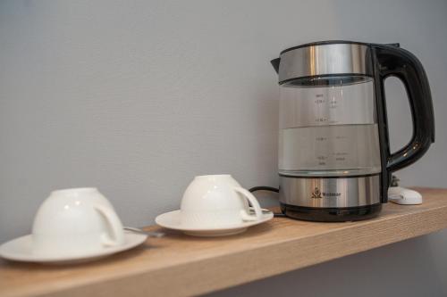 a blender on a wooden shelf with two white dishes at Easy Hotel T'bilisi in Tbilisi City