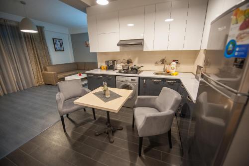 a kitchen with a table and two chairs and a sink at Easy Hotel T'bilisi in Tbilisi City