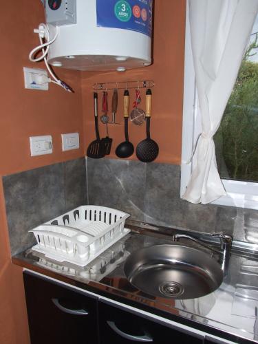 a kitchen counter with a dish drying rack and a sink at Cabaña Las hermanas in Capilla del Monte