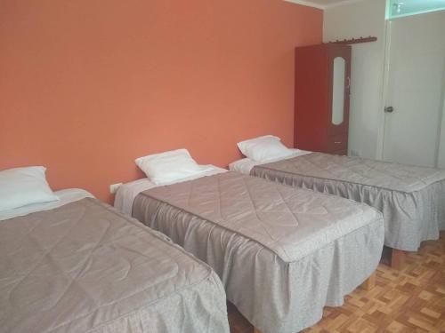 Pokój z 3 łóżkami i lustrem w obiekcie Hospedaje Golden Inn w mieście Camaná