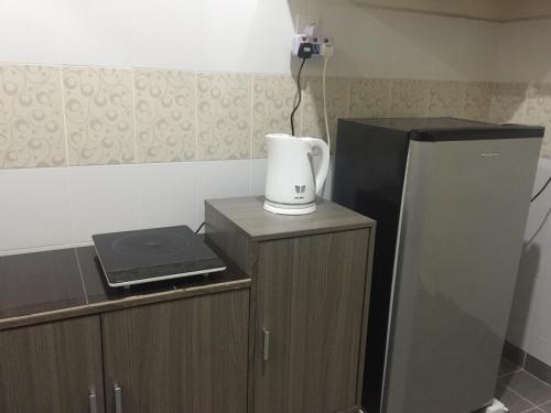 a kitchen with a refrigerator and a blender on a counter at Sri Nabalu Apartment Platinum Putatan in Kota Kinabalu