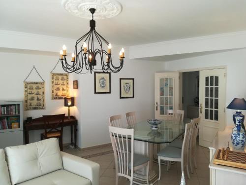 a dining room and living room with a chandelier at Porque Você Merece in Quarteira