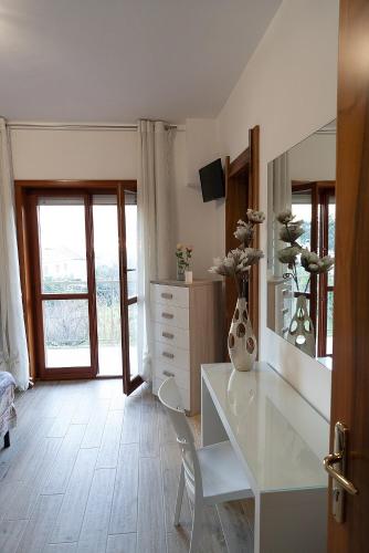 a white room with a desk and a mirror at B&B IL CAVALIERE in Baronissi