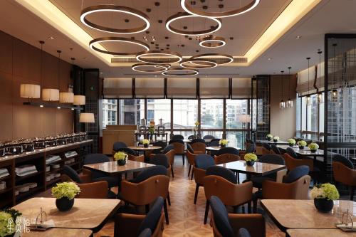 a restaurant with tables and chairs and windows at Royal Star Apartment(Guangzhou Central City Branch) in Guangzhou