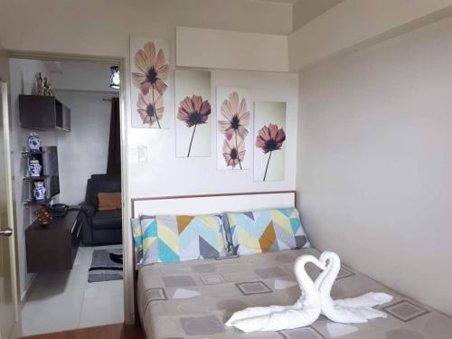 una sala de estar con una cama y flores en la pared en Spacious and cozy for families, en Davao City