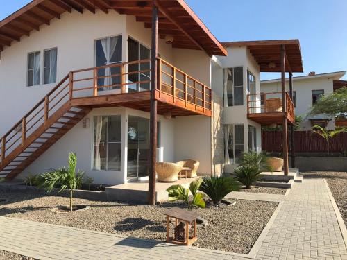 a house with a deck on the side of it at El Samay Hotel Boutique in Canoas De Punta Sal