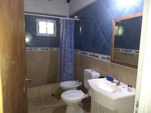 a small bathroom with a toilet and a sink at La Tribu in Paso de la Patria