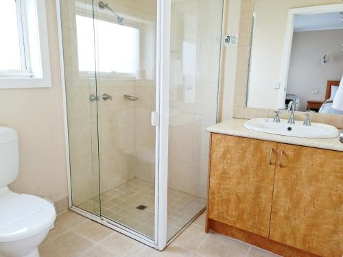 a bathroom with a shower and a toilet and a sink at Glen Inn in Glen Waverley