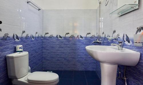 baño con lavabo y aseo con delfines en la pared en Sun View Resort Kithalella, en Ella