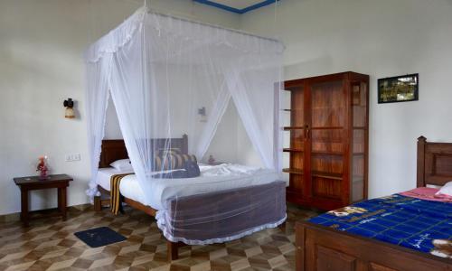 1 dormitorio con 1 cama con mosquitera en Sun View Resort Kithalella, en Ella