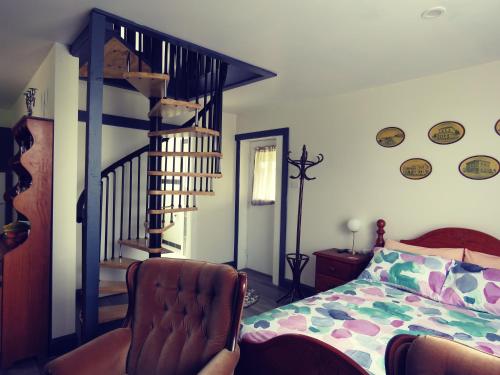a bedroom with a bed and a spiral staircase at Cape Nelson Cottage in Portland