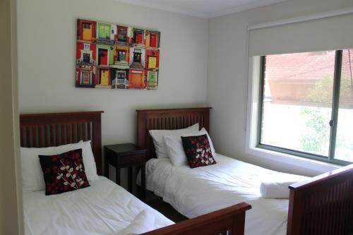 - une chambre avec 2 lits et une photo sur le mur dans l'établissement Australian Home Away Ringwood Bardia, à Ringwood