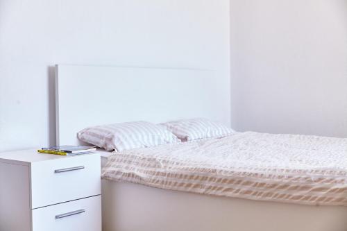 a white bedroom with a bed and a dresser at Love Dubrovnik Hostel in Dubrovnik