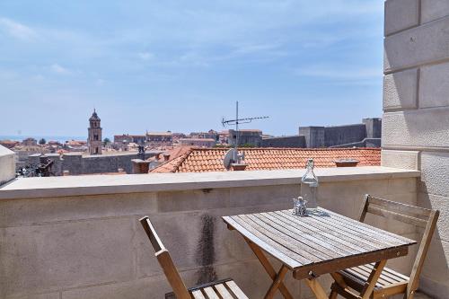a wooden table and two chairs on a balcony at Love Dubrovnik Hostel in Dubrovnik