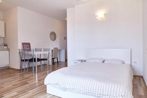 a white bedroom with a white bed and a table at Love Dubrovnik Hostel in Dubrovnik