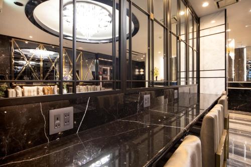 a restaurant with a black counter and a clock at The Grandeur Hotel in Kawasaki