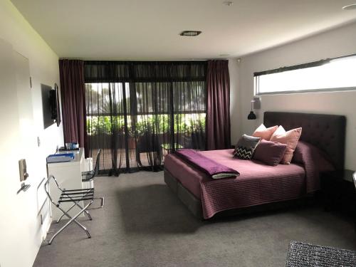 a bedroom with a bed and a large window at Starhaven Retreat in Portarlington