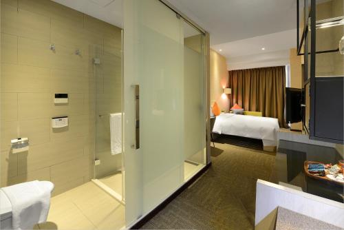 a bathroom with a shower and a bedroom with a bed at Via Hotel Taipei Station in Taipei