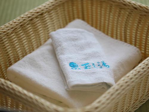 a wicker basket with towels on top of it at Hotel Tamanoyu in Matsumoto