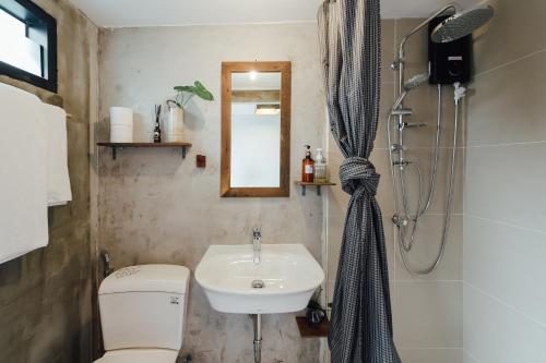 a bathroom with a sink and a toilet and a shower at The Yard Bangkok Hostel in Bangkok