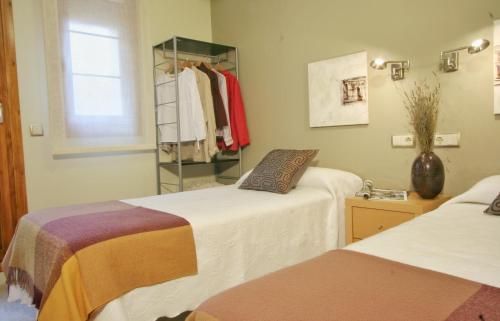 a bedroom with two beds and a rack of clothes at Apartamentos Uncastillo in Uncastillo
