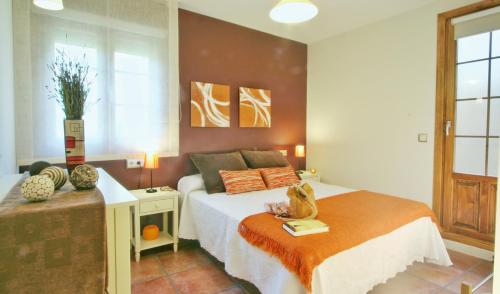 a bedroom with a bed with a cat sitting on it at Apartamentos Uncastillo in Uncastillo