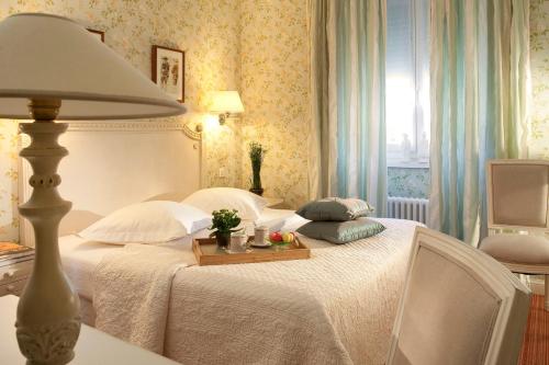 a bedroom with two beds and a table with a lamp at Gradlon in Quimper