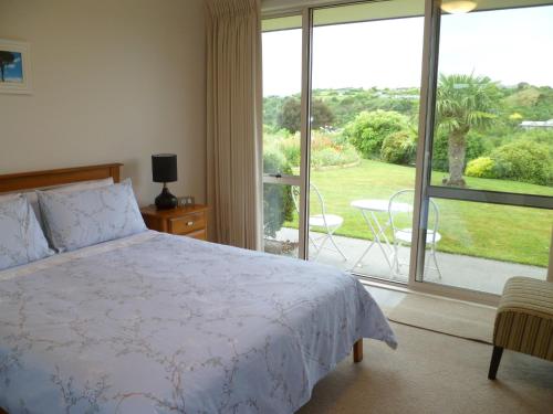a bedroom with a bed and a large window at Bellarosa B&B in Rotorua