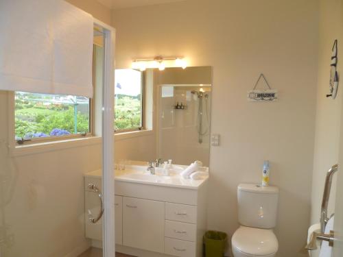 a bathroom with a sink and a toilet and a mirror at Bellarosa B&B in Rotorua