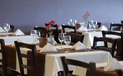 a group of tables with wine glasses and napkins at Aurora Hotel Klaipeda in Klaipėda