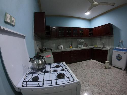 a kitchen with a stove with a tea kettle on it at Villa Girilena in Hikkaduwa