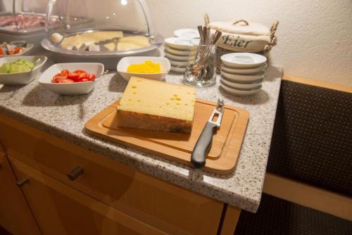 a cutting board with a piece of cheese on a counter at Hotel Garni Ragaz in Damuls