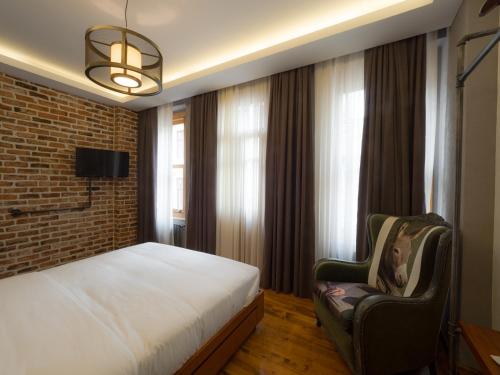 a bedroom with a bed and a brick wall at GalataCo Hotel in Istanbul
