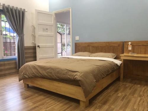 a bedroom with a large bed and a window at Ruby Dalat Hostel in Da Lat