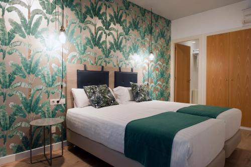 MH Apartments Sant Pau في برشلونة: غرفة نوم بسرير كبير وورق جدران