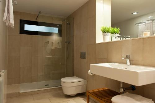 a bathroom with a toilet and a sink and a shower at MH Apartments Sant Pau in Barcelona